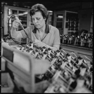 VEB Elektro-Apparate-Werke Berlin-Treptow „Friedrich Ebert“ (EAW), Bild 1: Frau mit Lötkolben bei der Arbeit. SW-Foto, 1960er Jahre © Kurt Schwarz.