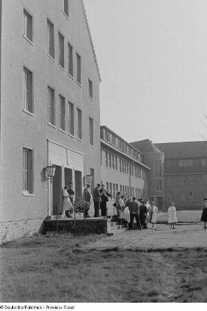 Angehende Pharmazeuten und Lehrkräfte vor dem Eingangsbereich der Fachschule für Apothekenassistenten