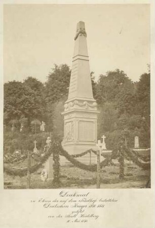 In Heidelberg der Friedhof unter Bäumen, Bildmittig die Ehrensäule mit den Namen der während des Frankreichfeldzugs 1870/71 gefallenen Soldaten