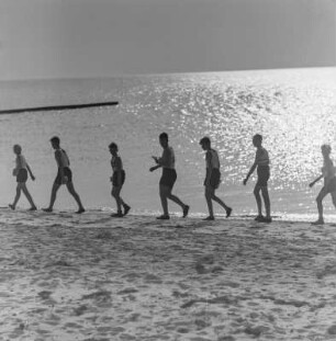 Jugendliche laufen am Strand entlang