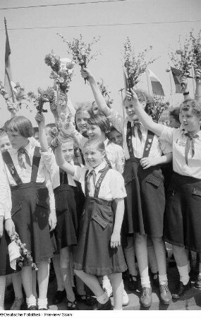 Mit Blumensträußen winkende Pioniere auf dem Karl-Marx-Platz