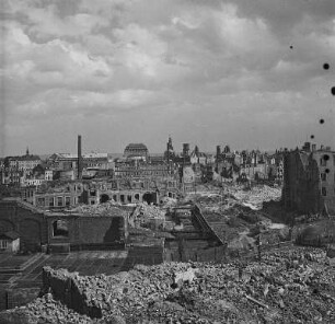 Blick über teilweise beräumte Trümmerlandschaft gegen Schauspielhaus, Hofkirche, Schloß und Türme der Sophienkirche nach Nordosten