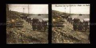 Personengruppe mit geretteter Habe am Hafen, Messina
