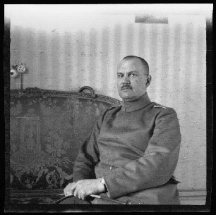 Fresnes-les-Montauban (Dep. Pas-de-Calais, Frankreich): Hauptmann Gaul in seinem Zimmer auf einem Sofa (Brustbild)