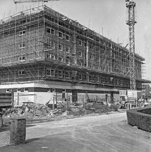 Möllner Landstraße / Twiete: Einkaufszentrum: Rohbau mit Gerüsten: davor Bauzaun, Baumaterial und rechts Bagger sowie Kran