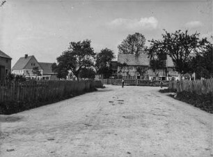 Dorfstraße : Lomnitz, Blick eine Straße entlang auf Häuser des Ortes