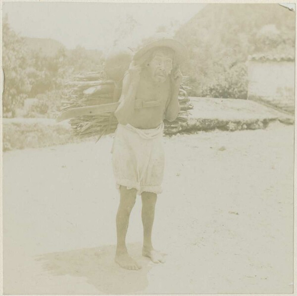 Man with a bundle of wood on his back