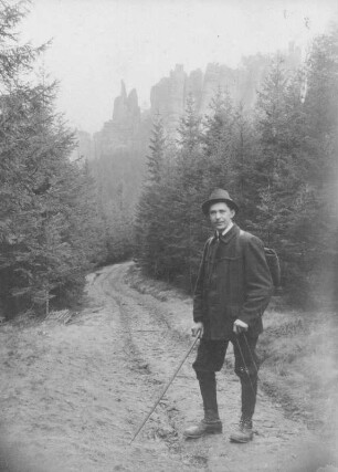 Sächsische Schweiz. Wanderer mit Spazierstock und Rucksack. Blick zu den Schrammsteinen