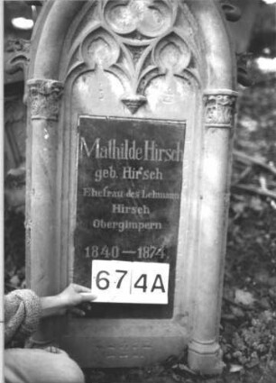Grabstein 674 (Index: 99900551) Material: Sandstein, Granit?tafel Zustand: gut erhalten, Stele vom Sockel gestürzt Maße HxBxT: 190x52x22 cm Beschreibung: ursprünglich aufgesockelte Stele mit Spitzbogenabschluss, Oberrahmen mit Krabben besetzt, im Bogenfeld Maßwerk, die Schriftfelder flankiert von Säulen, vom Sockel gestürzt lehnt an diesem: Grabstein 674A
