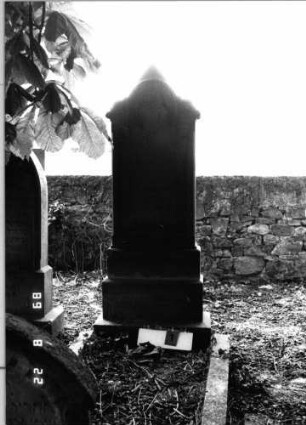 Grabstein 1 (Index: 99797996) Material: Sandstein, weiß Zustand: gut Maße HxBxT: 192x62x20 cm Beschreibung: Stele, eingezogener Rundbogenabschluß mit dreieckigem Aufsatz, getreppter Sockel Symbolik: neogotisch, Maßwerk, Dreipaßbogen: Grabstein 1 (2)