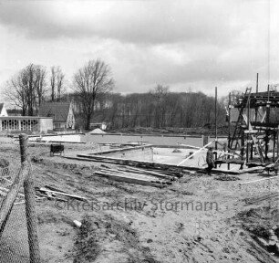 Freibad: Reeshoop: Schwimmbecken in Bau, mit Fliesen: rechts Sprungturm in Bau, Gerüst: Arbeiter, Holzbalken: hinten links Filterhaus: im Hintergrung Wohnhaus am Reeshoop