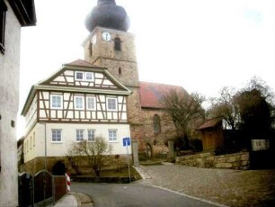 Ansicht von Norden mit Kirche (über Kirchturm und Langhaus) sowie Pfarrhaus von Ortsseite