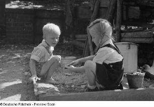 Zwei Kinder beim Spiel im Sandkasten