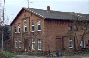 Sehmsdorf: Fischertwiete 14: giebelständiges Bauernhaus aus Backstein: Straßenfront mit Eingangstür: Traufseite, Teilansicht: davor Jägerzaun, rechts Hofeinfahrt