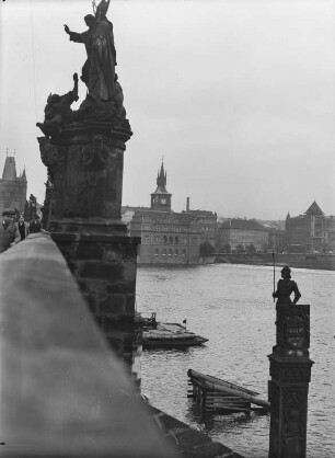 Die Rolandssäule : Die Rolandssäule rechts an der Karlsbrücke in Prag und die Statuen des Heiligen Vinzenz Ferrer und des Heiligen Prokop auf der Brücke links, die sich über die Moldua spannt.