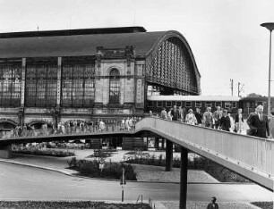 Hamburg-Rotherbaum. Reisende von und zum Bahnhof Dammtor auf der Dag-Hammarskjöld-Brücke. Im Hintergrund die Empfangshalle des Bahnhofes