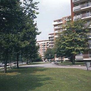 Hansjakob, Gottfried; München - Neuperlach Mitte; Wohnring Neuperlach - Außenraum (Fassadenansicht), Grünanlage zur Straße hin, Möblierung und Mastleuchten