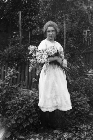 Frau mit Blumenstrauß in einem Garten