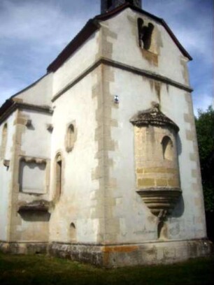 Kirchturm von Ostsüdosten mit Chorapside sowie Biforium (reiche Ornamentierung und Steinplastiken) und Langhaus im Ansatz