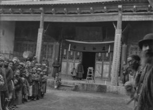 Tempelanlage : Ein Empfang vor einem Gebäude im chinesischen Baustil, möglicherweise ein Tempel im Tian Shan Hochgebirge