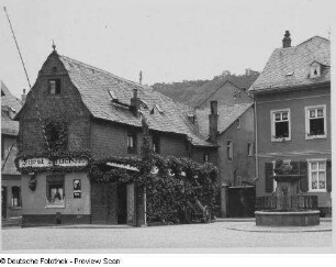 Kaub, Marktplatz 1 und 3. Wohnhaus (Nummer 1, jetzt Hindenburg-Apotheke) und Gasthaus "Fürst Blücher". Straßenansicht mit Marktbrunnen (1828)