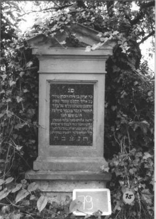 Grabstein 75 (Index: 99805343) Material: Sandstein, schwarze Marmorplatte Zustand: Sockel völlig verwittert Maße HxBxT: 142x52x28 cm Beschreibung: Stele, Sockel, Giebel mit Verdachung, rechteckige Schriftplatte: Grabstein 75
