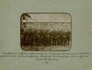 16 Offiziere des 1. Bataillons in Uniform, mit Pickelhaube teils mit Orden, stehend vor Mauerwerk