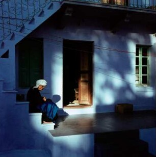 Kalymnos. Alte Frau vor einem Haus in der Oberstadt sitzend