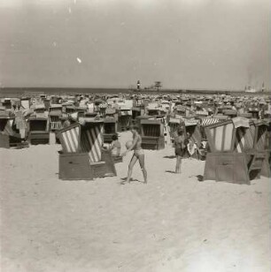 Rostock-Warnemünde. Strand mit Strankörben und Badegästen. Blick zur Westmole