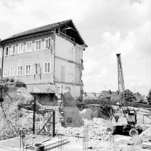 Erweiterungsbau [später Gebäude C] mit Kreistagssitzungssaal: IV. Bauabschnitt: Abbruch von Giebelwand und Fundament des Erweiterungsbaus II. Bauabschnitt an Reimer-Hansen-Straße: im Vordergrund Baugrube mit Bagger