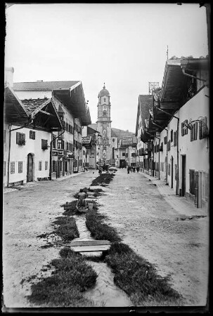 Mittenwald. Blick zur Pfarrkirche Sankt Peter und Paul mit Wasserlauf