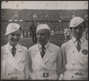 Drei Frauen, die die olympischen Medaillen bei den Siegerehrungen verleihen