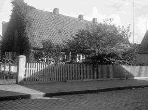 Wohnhaus hinter einem Zaun