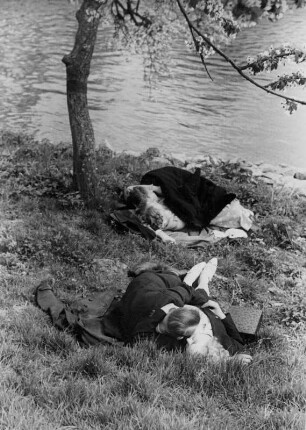 Frühlingserwachen. Liebe in der Baumblüte. Paare liegen auf einer Wiese