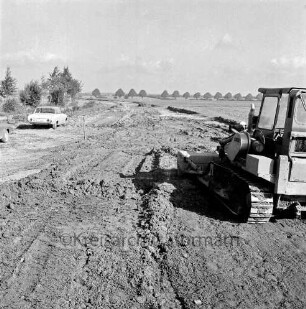 Kreisstraße zwischen Glinde und Reinbek: Neubau: Ausschachtung für die neue Straße durch das Industriegebiet Reinbek/Glinde/Schönningstedt: rechts Bagger: hinten links zwei Pkws: dahinter Bäume