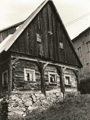 Sebnitz. Obergasse. Altes Umgebindehaus mit Feldsteinuntermauerung und Blechdach. Giebelansicht