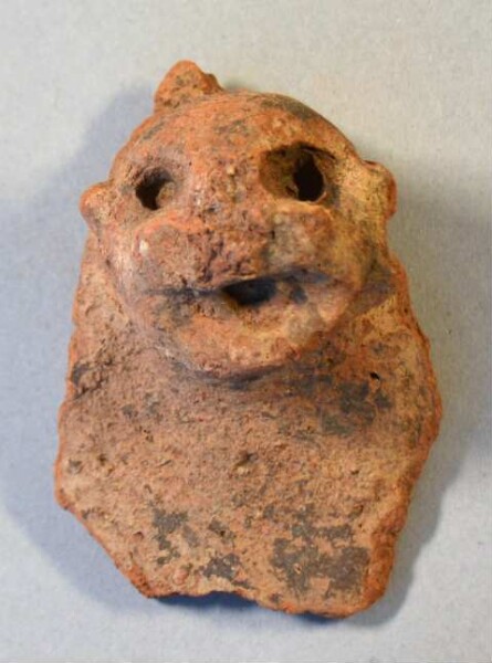 Clay head (fragment of a burial urn ?)