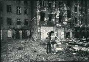 Zwei kleine Jungen posieren vor verfallenen Häusern (Prämiertes Foto Sonderthema: Kein Platz für Kinder)