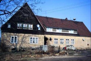Gebäude mit Holzverkleidung am Giebel; Sirene auf dem Dach