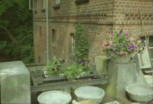 Mühlenstraße 10: Wassermühle: Detailaufnahme: Geländer der Brücke über Gerinne und Glinder Au: Zahnräder und Gestänge-Teile: hinten Seitenansicht Mühlengebäude: