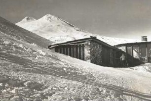 Zentralkaukasus. Skipiste am Tscheget. Café an der Mittelstation gegen Elbrus-Doppelgipfel (5633 und 5621 m)