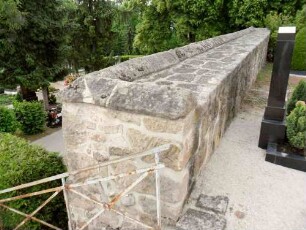 Kirchhofmauer im Westen im Querschnitt mit Werksteinen im Mauersteinverband (Steinbrüstung mit Schießscharten sowie hölzernen Laufgang im 18 Jh abgetragen)