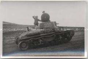 Zwei Soldaten, einer mit Kamera, auf einem sowjetischen Panzer