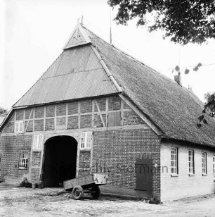 Rohlfshagen: Reetdachhaus von Bürgermeister Heinrich Schultz: davor einachsiger Anhänger: rechts oben Baumäste
