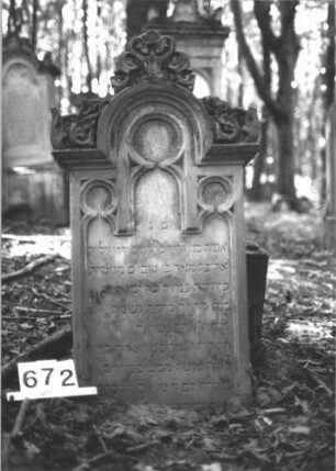 Grabstein 672 (Index: 99900555) Material: Sandstein Zustand: Inschriften gut erhalten, Stele herunter gestürzt Maße HxBxT: 149x59x24 cm Beschreibung: ursprünglich aufgesockelte Stele mit eingezogenem Rundbogenabschluss, Akanthusaufsätze auf Giebel und Ecken, Schriftfeld oben von Maßwerk gerahmt, Stele vom Sockel herunter gestürzt, lehnt davor Symbolik: Akanthus: Grabstein 672