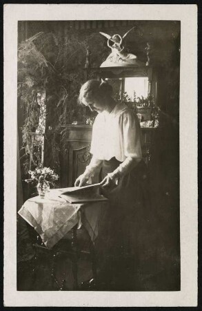 Portrait einer Dame : Postkarte mit Portrait einer Dame beim Betrachten eines Buches