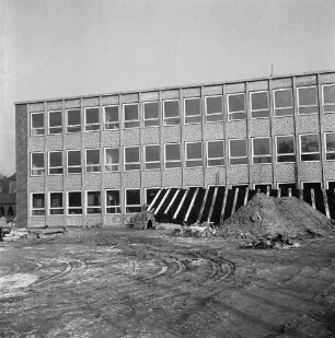 Sachsenwaldschule Gymnasium Reinbek: Schulstraße: Erweiterungsbau: vor Fertigstellung: vorn unbefestigtes Schulgelände mit Resten von Baumaterial, Sandhaufen und Bauzaun