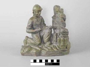 Skulptur eines Bergmanns beim Besetzen eines Sprenglochs