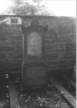 Grabstein 21 (Index: 100105742) Material: Sandstein und Marmor Zustand: stärker verwittert am Sockel Maße HxBxT: 158x64x31 cm Beschreibung: Stele, getreppter und profilierter Sockel, Giebel mit Akroteren, Schriftfeld eingetieft: Grabstein 21