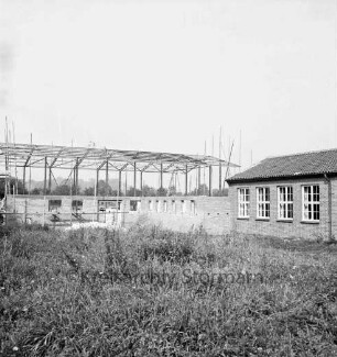 Turnhalle: Volksschule: Hamburger Straße: Rohbau: Stahlkonstruktion: rechts daneben Anbau: vorn rechts Schulpavillon: vorn verkrautete Wiese